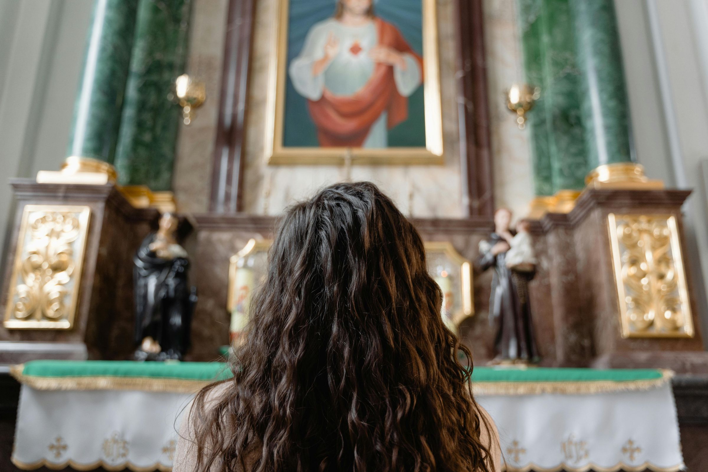 Young woman kneeling in front of an altar in prayer